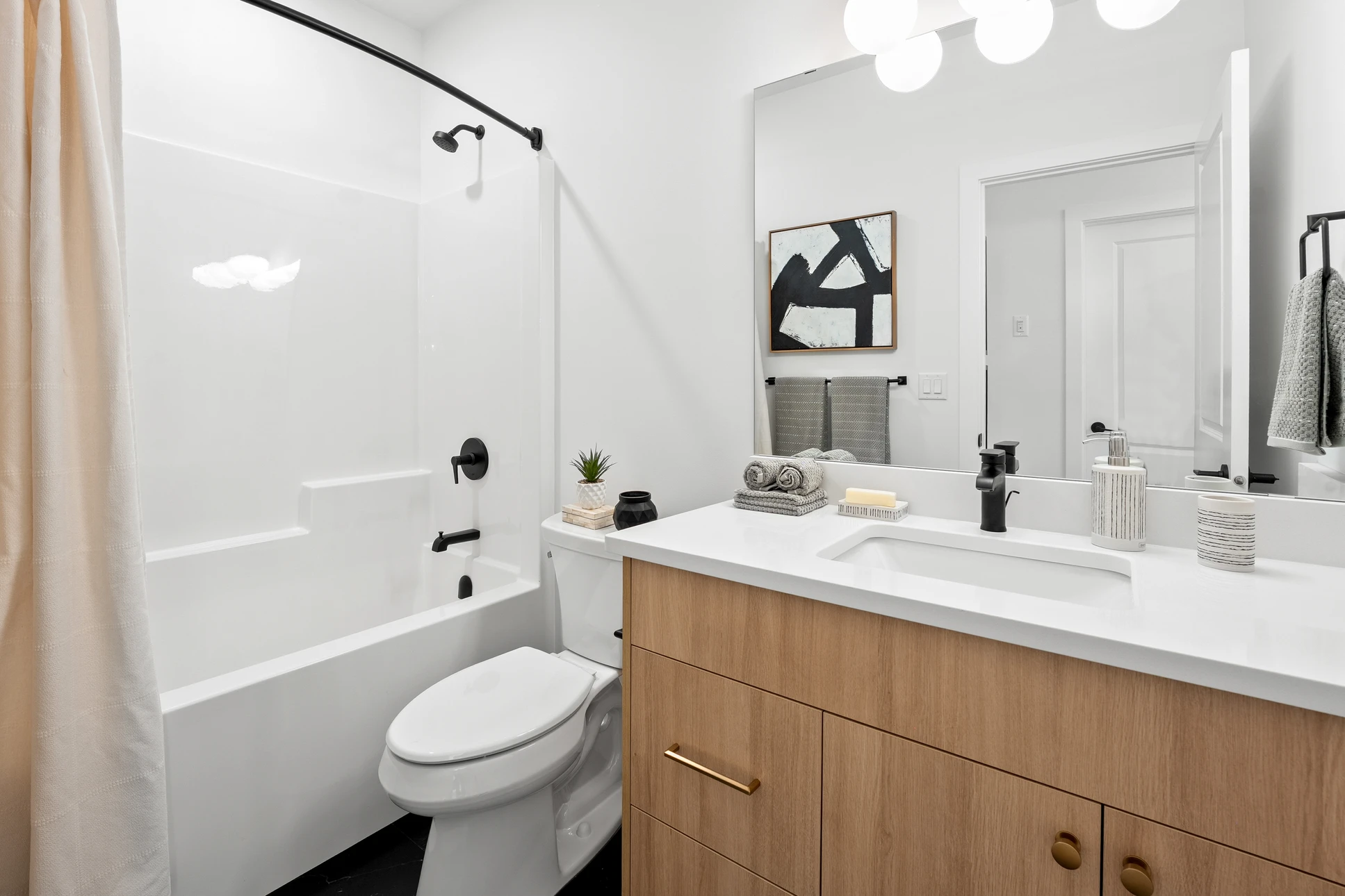 Salle de bain moderne avec douche à l'italienne, carrelage blanc et gris, receveur de douche carrelé, paroi de douche en verre, colonne de douche thermostatique